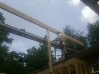 Carpenter setting a ridge beam over a new addition frame — Ice Dam Removal by Roofing Brothers in West Linn
